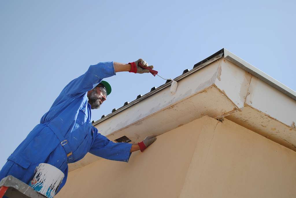 a-worker-paints-the-eaves-of-a-building-maintained-4ebf42-1024