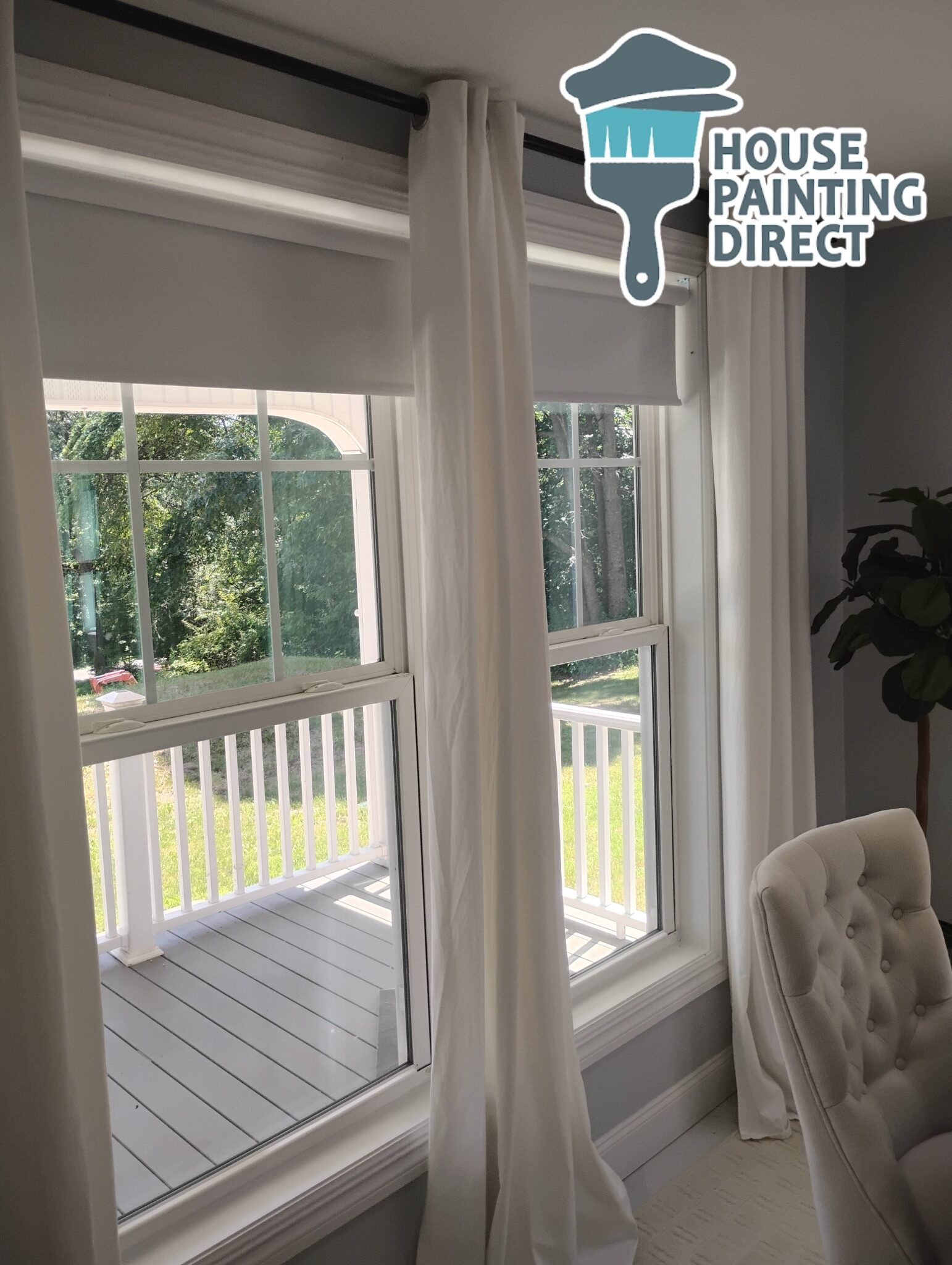Worker painting wall with spray gun in white color.